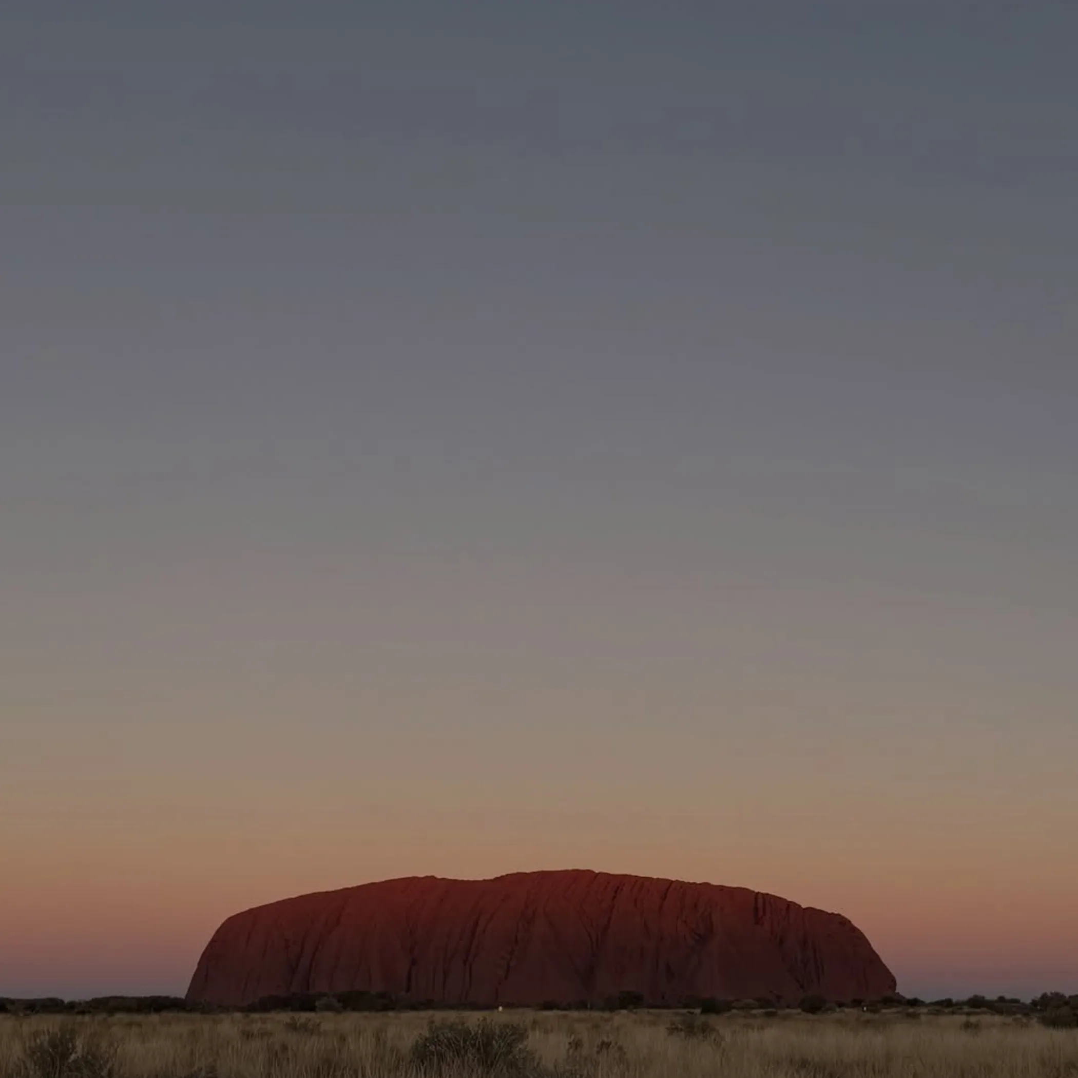 tourists walking base of ayers rock